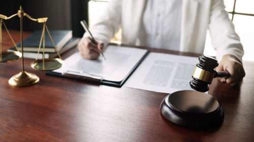 Midsection of man using mobile phone on table