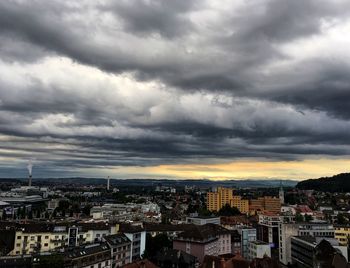 Aerial view of cityscape against storm clouds