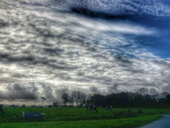 Scenic view of grassy field against cloudy sky