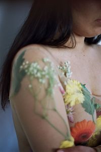 Cropped image of naked woman covered with flowers