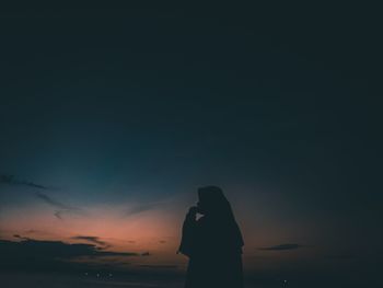 Rear view of silhouette woman standing on beach