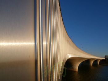 Low angle view of bridge against clear blue sky