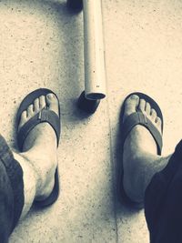 Low section of man standing on tiled floor