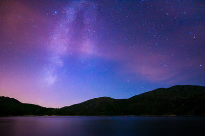 Scenic view of lake against mountain at night