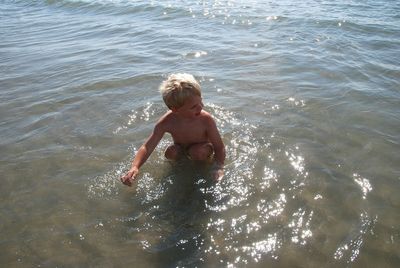 High angle view of shirtless boy in sea