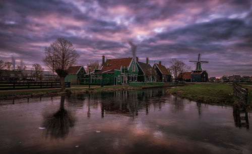 Reflection of built structure in water against sky