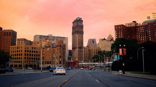 Street and cityscape against sky during sunset