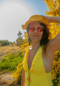 Portrait of young woman wearing hat standing against sky