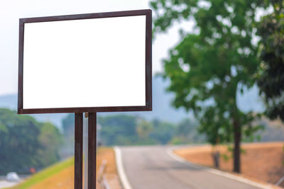 Close-up of empty road against trees