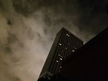 Low angle view of modern building against cloudy sky