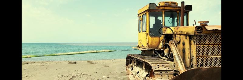 Abandoned ship on beach against sky