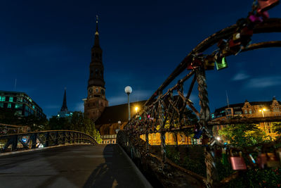 View of illuminated bridge and buildings at night