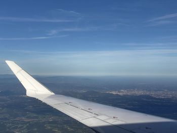 Airplane flying over clouds against blue sky