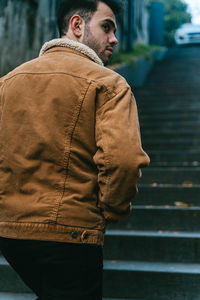 Rear view of man standing against wall