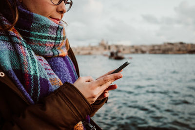 Midsection of man using mobile phone outdoors