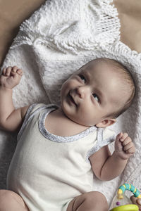 High angle view of cute baby lying on blanket