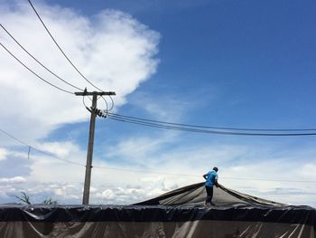 Low angle view of man against blue sky