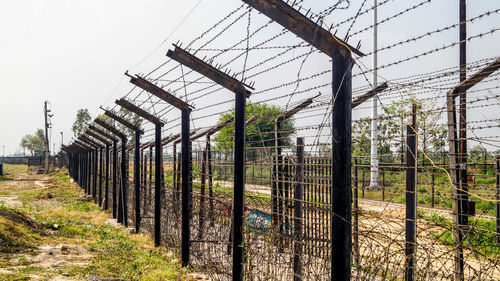 Fence on field against sky