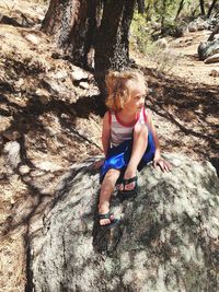 Boy sitting on rock