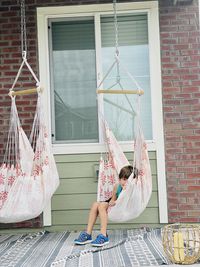 Full length of girl hanging outside building