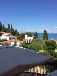 Buildings by sea against clear blue sky