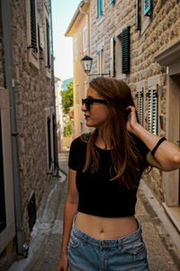 Young woman standing against building in city