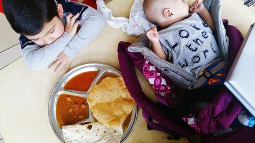 High angle view of siblings by food on table