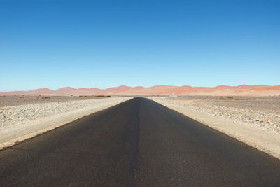 Scenic view of desert against clear blue sky