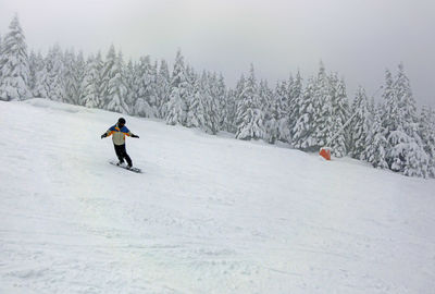 Woman walking on snow covered land