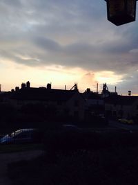 Buildings against cloudy sky at dusk