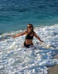 Young woman in bikini swimming in sea