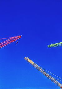 Low angle view of airplane flying against clear blue sky