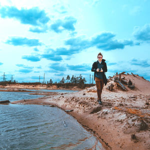 Full length of man standing on beach against sky