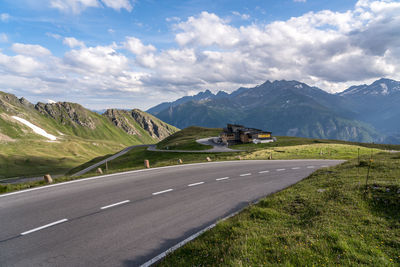 Road leading towards mountains against sky