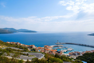 High angle view of buildings by sea against sky