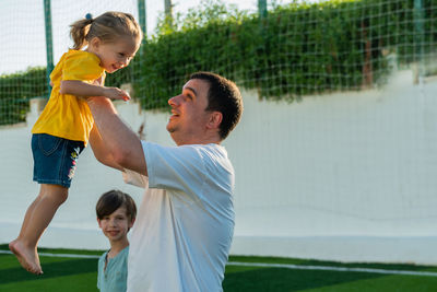 Happy father holding daughter in hands and looking at her