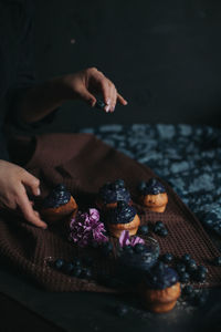 Midsection of man holding ice cream on table