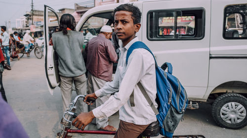 Side view of man standing on street in city