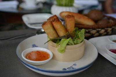 Close-up of spring rolls in bowl at table