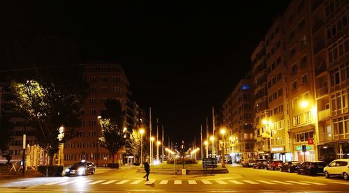 Illuminated city street and buildings at night