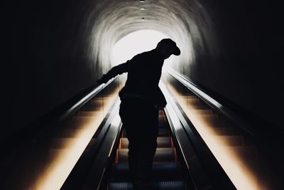 Low angle view of silhouette man standing on escalator