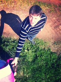 Portrait of young man standing on grassy field