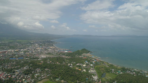 High angle view of city by sea against sky