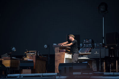 Full length of young man sitting on stage