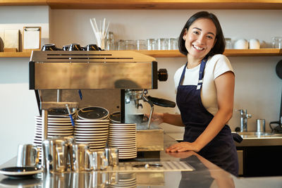 Portrait of young woman holding coffee in cafe