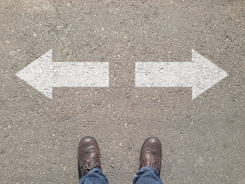 Low section of man standing on road