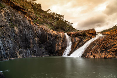 Scenic view of waterfall against sky