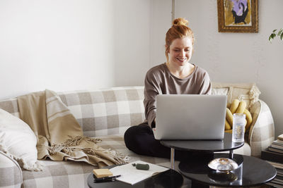 Smiling woman using laptop at home