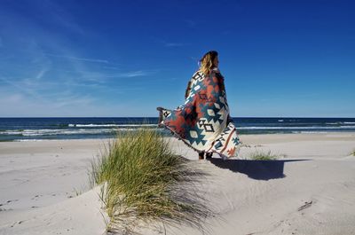Person on beach against sky
