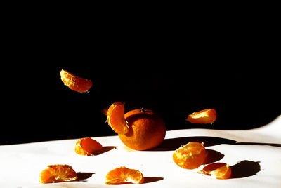 Close-up of orange fruits on table against black background